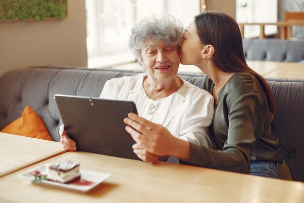 Menina ensinando a avó como usar um tablet