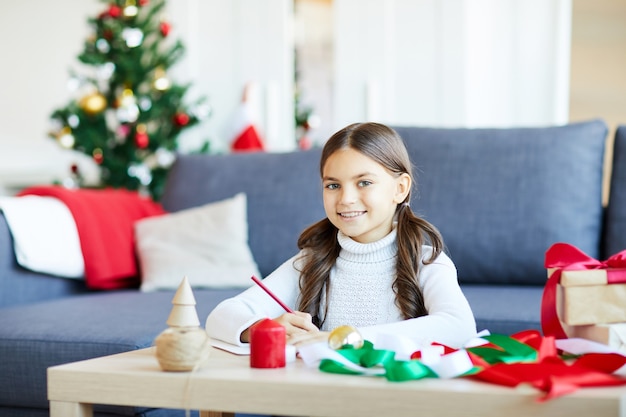 Menina escrevendo uma carta para o Papai Noel