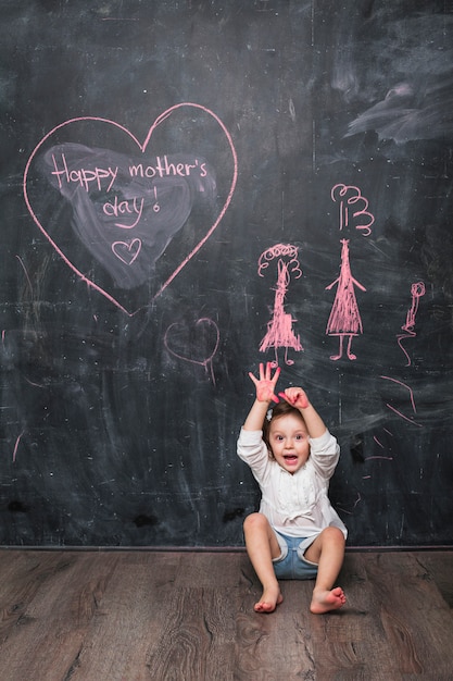 Menina espantada sentado perto de inscrição feliz dia das mães