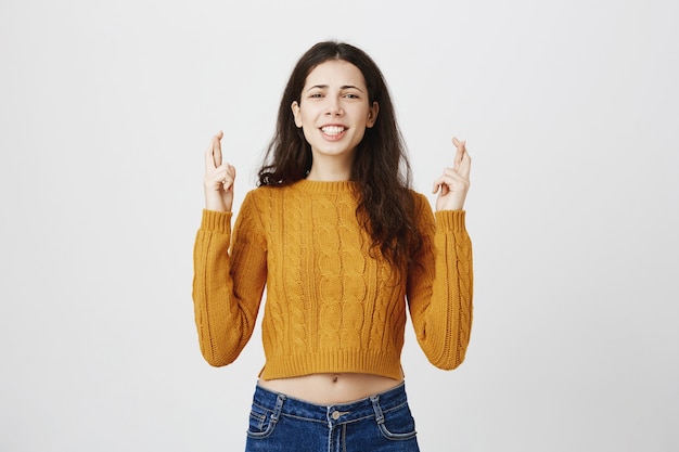 Foto grátis menina esperançosa cruzando os dedos e fazendo desejo