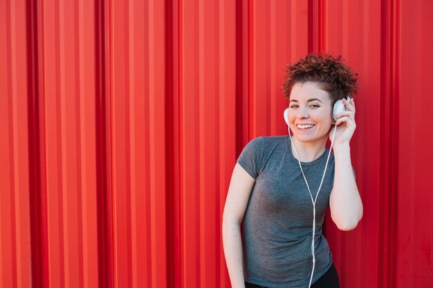 Menina esportiva alegre em fones de ouvido