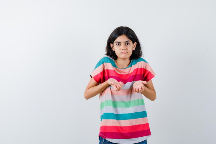 Foto grátis menina esticando as mãos de forma questionadora em t-shirt e parecendo perplexa. vista frontal.