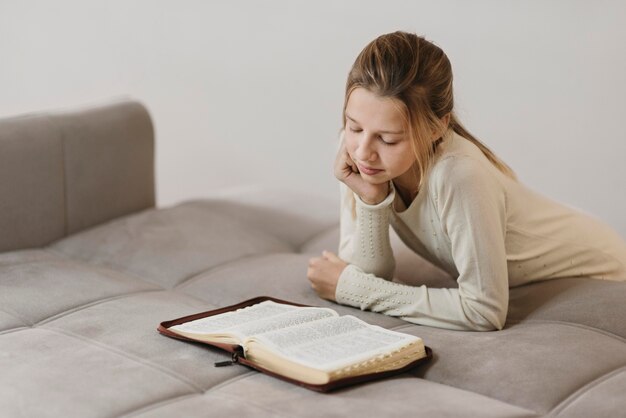 Menina estudando um livro sagrado