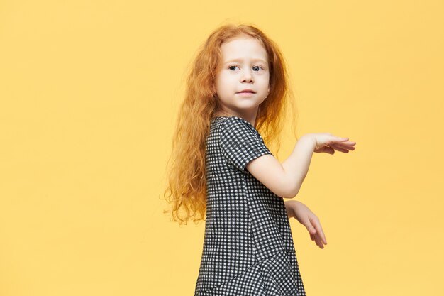 Menina europeia encantadora e bonita em um vestido elegante dançando ao som de música