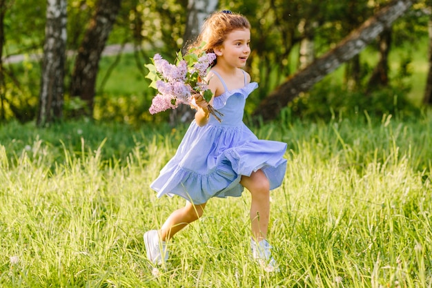 Menina, executando, ligado, capim, com, grupo flores