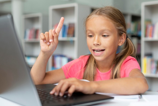 Foto grátis menina fazendo a lição de casa na biblioteca