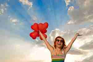 Foto grátis menina feliz com balões em forma de coração