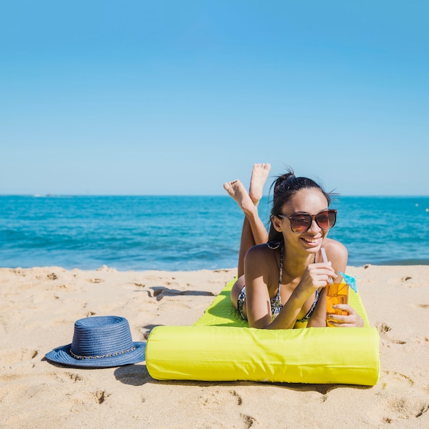 Menina feliz deitada na praia