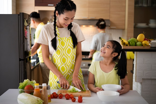 Menina feliz e mãe cozinhando