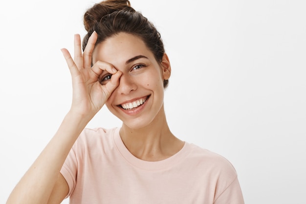 Foto grátis menina feliz e sonhadora posando contra a parede branca