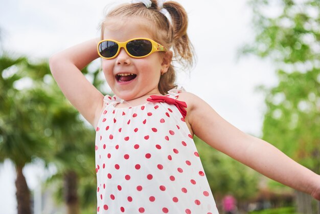 Menina feliz em um óculos de sol de verão.