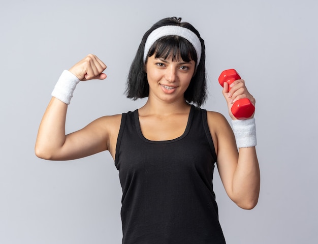 Menina feliz fitness jovem usando bandana segurando halteres, fazendo exercícios levantando o punho mostrando os bíceps