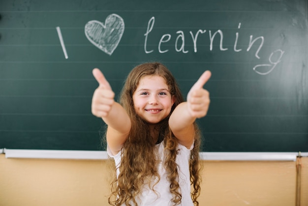 Menina feliz gesticulando na aula