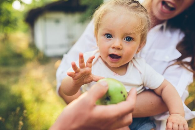 Menina feliz olhando como eles oferecem-lhe uma maçã