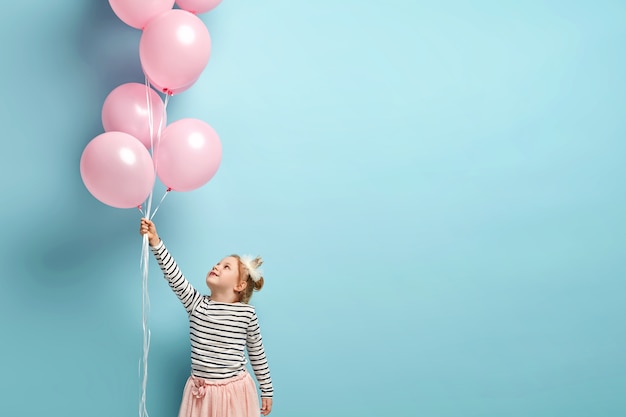 Menina feliz segurando balões