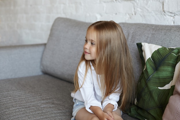 Foto grátis menina feliz sentada na sala de estar