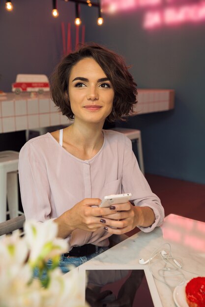 Menina feliz sorridente, segurando o telefone móvel