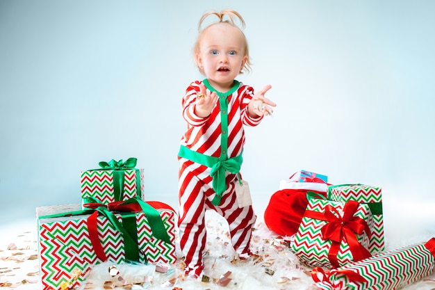 Menina fofa de 1 ano com chapéu de Papai Noel posando no Natal