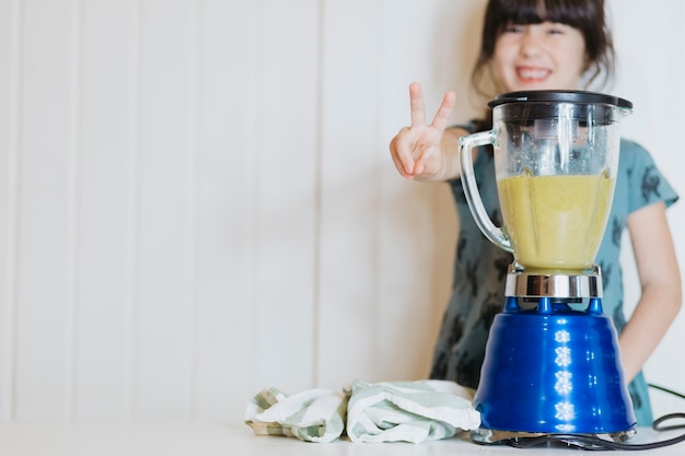 Menina gesticulando ao fazer smoothie