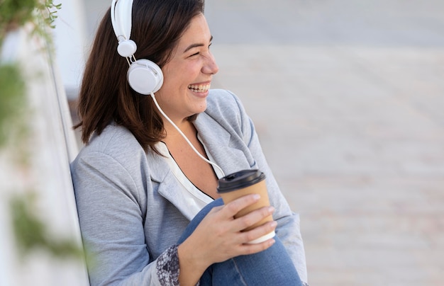 Menina gordinha ouvindo música ao ar livre