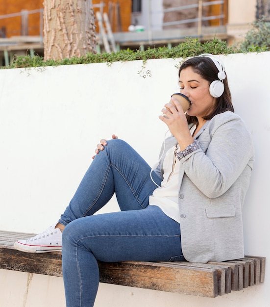 Menina gordinha tomando um café ao ar livre