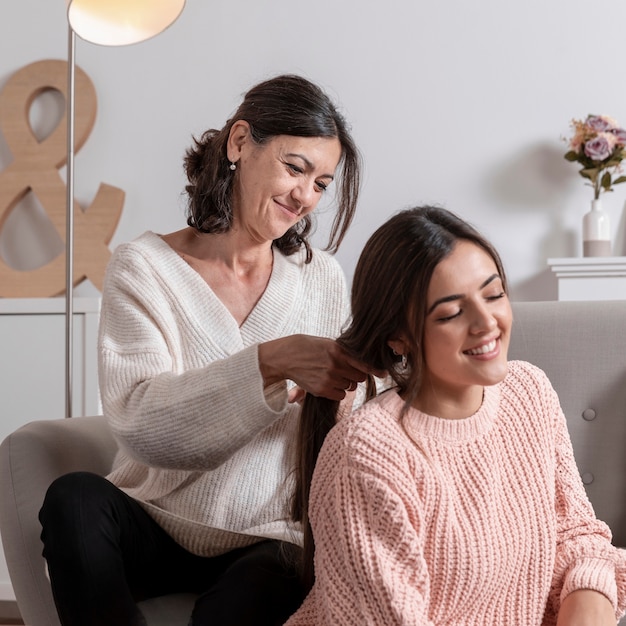 Foto grátis menina haid trançado pela mãe