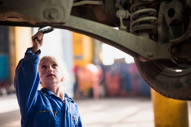 Menina inspecionando o carro com lupa