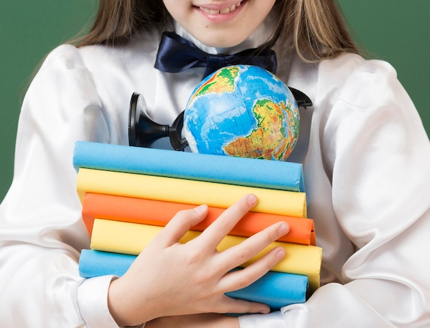 Foto grátis menina irreconhecível, segurando a pilha de livro