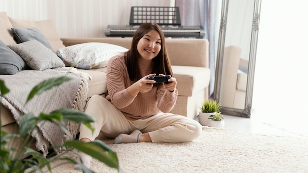 Menina jogando jogo com controle de tiro completo