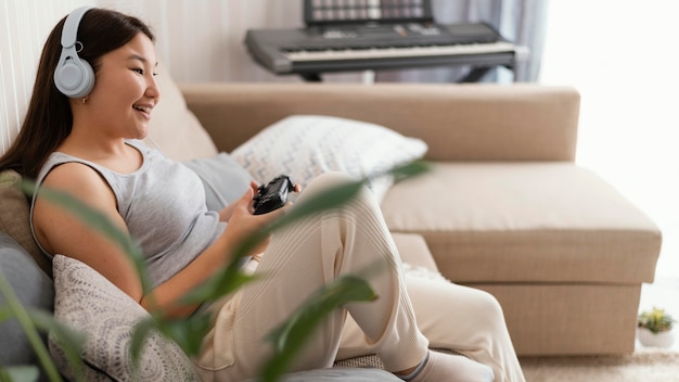 Foto grátis menina jogando videogame no sofá