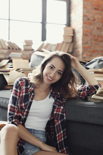 Menina jovem adolescente lendo um livro em casa