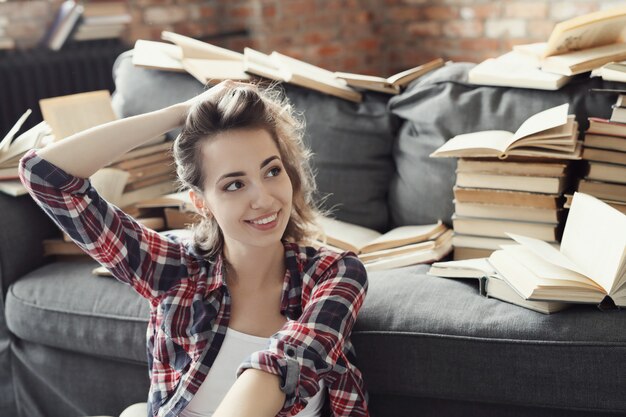 Menina jovem adolescente lendo um livro em casa