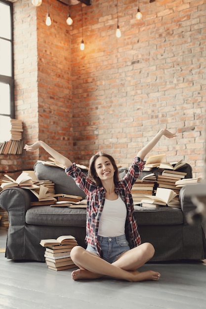 Menina jovem adolescente lendo um livro em casa