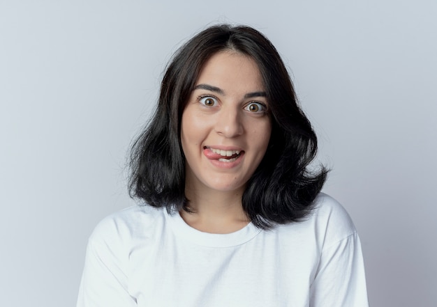 Foto grátis menina jovem e bonita caucasiana brincalhona mostrando a língua isolada no fundo branco