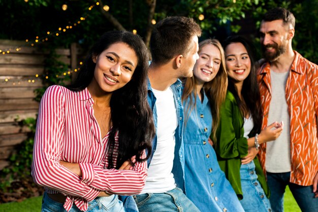 Menina jovem, olhando câmera, com, amigos, atrás de