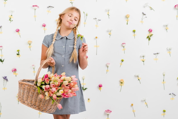 Menina jovem, segurando cesta, com, flores
