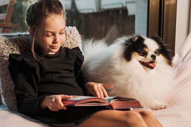Menina lendo e cachorro ouvindo