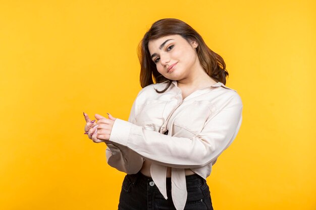 Menina linda sorrindo para a câmera em fundo amarelo Foto de alta qualidade