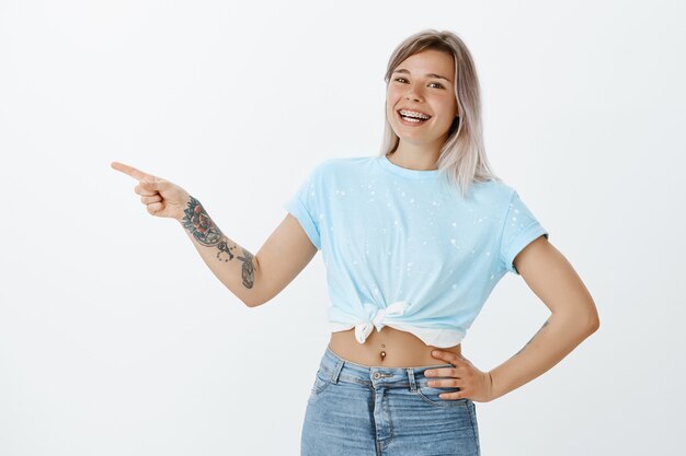 Menina loira alegre e despreocupada posando no estúdio