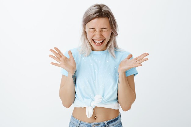 Menina loira alegre posando no estúdio