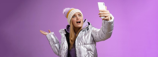 Foto grátis menina loira chateada e chorosa reclamando que não consegue encontrar o ângulo certo, tirar uma selfie com uma vista legal