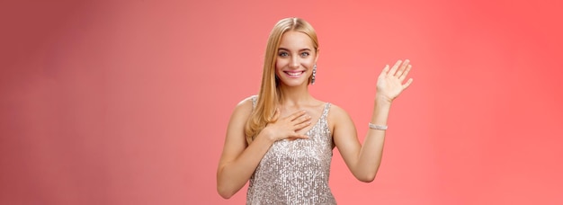 Foto grátis menina loira feliz diz olá apresenta-se namorado amigos levantam a mão acenando olá gestos pressionar