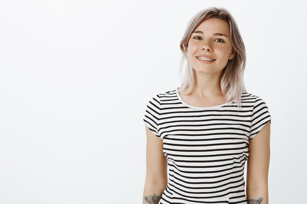 Menina loira positiva posando no estúdio