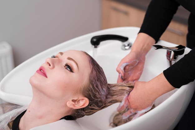 Menina loira, recebendo seu cabelo lavado