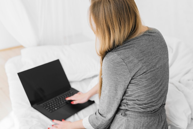 Foto grátis menina loira usando laptop na cama