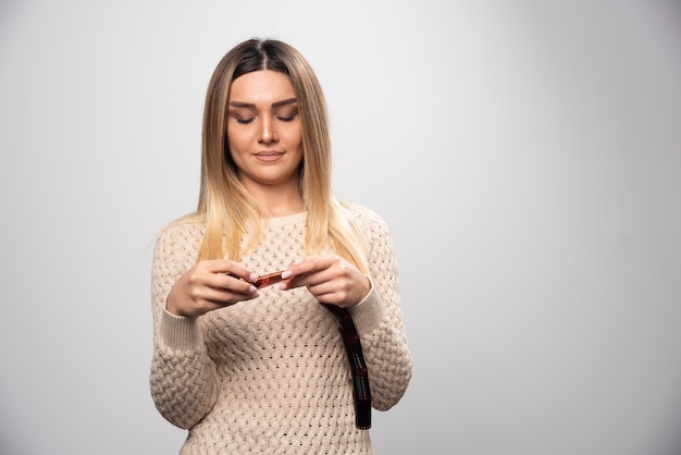 Menina loira, verificando atentamente as fotos no rolo de fotos.