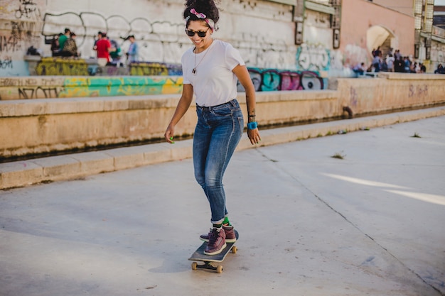 Foto grátis menina morena andando no skate na rua