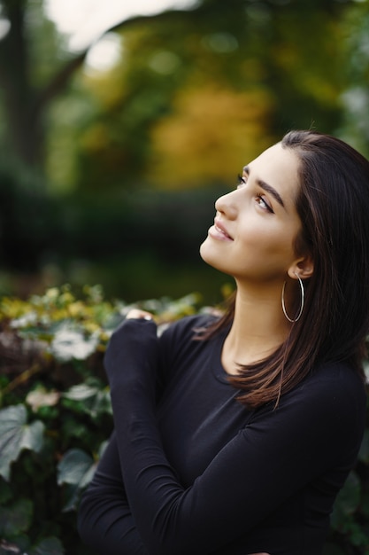 Foto grátis menina morena andando pelo parque durante o outono