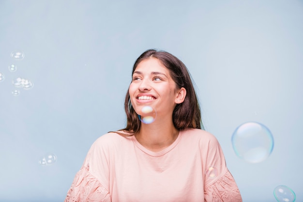 Menina morena brincando com bolhas de sabão