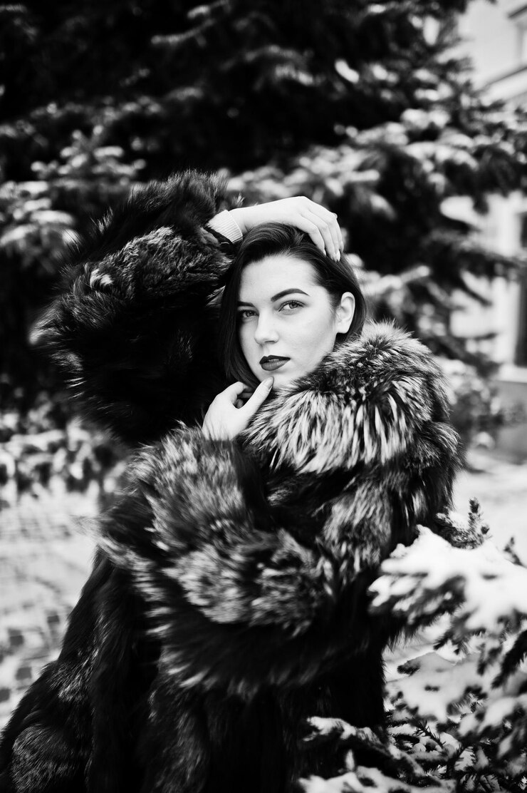 Foto grátis menina morena com casaco de pele verde no dia de inverno contra pinheiro nevado